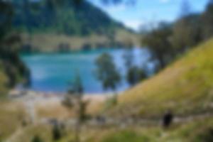 visão turva do lago ranu kumbolo, montanha semeru. bokeh de fundo no verão, conceito de natureza verde foto