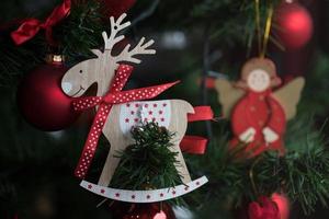 um ornamento de rena de madeira em uma árvore de natal foto