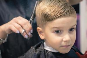 menino pensativo no salão de cabeleireiro. foto