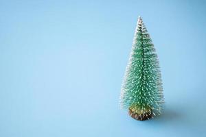 árvore de natal verde sobre fundo azul pastel conceito de celebração de férias de ano novo foto