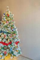 Natal clássico decorado árvore de ano novo com brinquedo de ornamento azul e branco vermelho e bola no fundo da parede cinza. apartamento de design de interiores de estilo clássico moderno. véspera de natal em casa. copie o espaço. foto