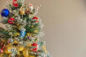 Natal clássico decorado árvore de ano novo com brinquedo de ornamento azul e branco vermelho e bola no fundo da parede cinza. apartamento de design de interiores de estilo clássico moderno. véspera de natal em casa. copie o espaço. foto