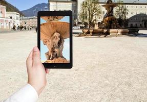 turista tirando foto da fonte em salzburgo