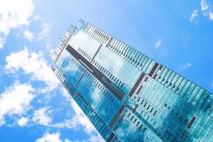 kuala lumpur, malásia, 21 de fevereiro de 2020 vista inferior no arranha-céu em um fundo de céu azul com reflexo de nuvens nas janelas. foto