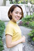 mulher asiática com cabelo curto dourado usa uma t-shirt de manga curta cor amarela. foto