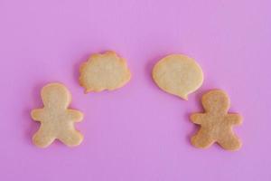 biscoitos caseiros de shortbread no fundo rosa, vista superior. duas pessoas com mensagem em branco de bolha de texto explicativo. foto