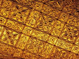 belos motivos de arte birmanesa design decorativo nas paredes douradas dos quartos do templo foto