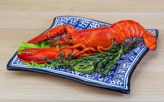 lagosta cozida no prato e fundo de madeira foto