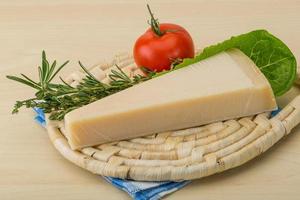 queijo parmesão na tábua de madeira e fundo de madeira foto