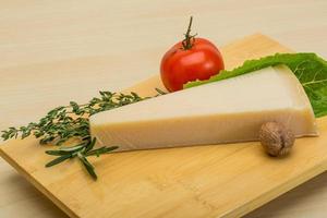 queijo parmesão na tábua de madeira e fundo de madeira foto