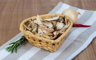 shiitake seco em uma cesta em fundo de madeira foto