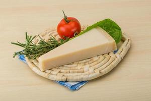 queijo parmesão na tábua de madeira e fundo de madeira foto