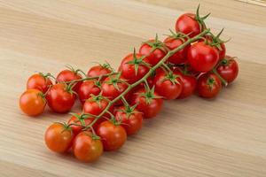 tomate cereja em fundo de madeira foto