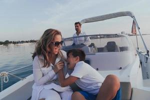 um casal sênior em roupas casuais com seu filho desfruta enquanto andava de barco no mar ao pôr do sol. o conceito de uma família feliz. foco seletivo foto