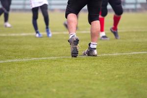 close-up de jogadores de futebol americano esticando e aquecendo foto