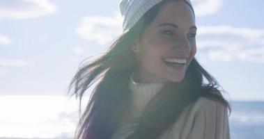 garota com roupas de outono sorrindo na praia foto