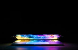 laptop colorido em quarto escuro