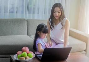 mãe e filha usando um laptop