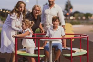 um casal de idosos em roupas casuais com seus filhos e avó passam tempo juntos no parque de férias. tempo para a família. foco seletivo foto