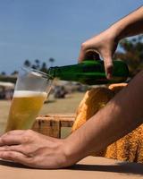 derramando cerveja na praia foto