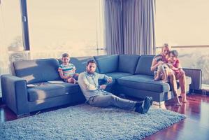 família jovem feliz jogando juntos no sofá foto