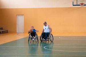 Veteranos de guerra com deficiência, equipes de basquete opostas de raça mista em cadeiras de rodas fotografadas em ação enquanto jogavam uma partida importante em um salão moderno. foto