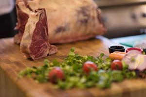 suculenta fatia de bife cru na mesa de madeira foto