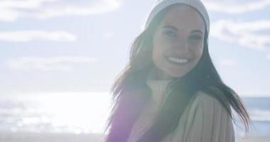 garota com roupas de outono sorrindo na praia foto