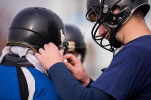 jogadores de futebol americano verificando capacetes foto