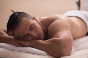 homem bonito descansando em um centro de massagem spa foto