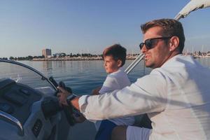 pai e filho aproveitam as férias juntos enquanto andam em um barco de luxo no mar. foco seletivo foto
