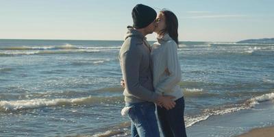 casal se divertindo em lindo dia de outono na praia foto