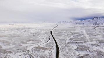 uma estrada através de uma paisagem coberta de neve foto