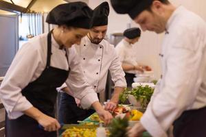 cozinheiros e chefs de equipe preparando a refeição foto