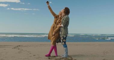 meninas tendo tempo e tomando selfie na praia foto