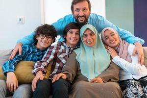 foto de retrato de uma família muçulmana árabe sentado em um sofá na sala de uma grande casa moderna. foco seletivo