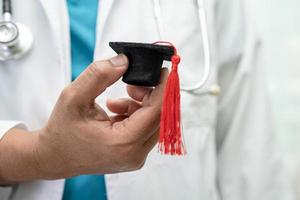 estudo de médico asiático aprende com chapéu de graduação na enfermaria do hospital, conceito de medicina de educação de gênio brilhante inteligente. foto