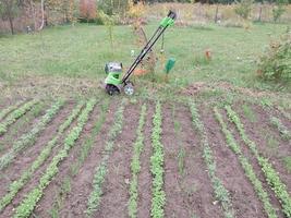 oblast de kyiv, ucrânia - 02 de outubro de 2022 cultivo de canteiros com um cultivador elétrico manual foto