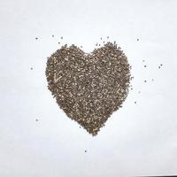 coração de sementes de chia isoladas no fundo branco. superalimento saudável foto