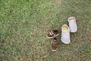 sapatos de mãe e filho deixados no campo para brincar juntos foto