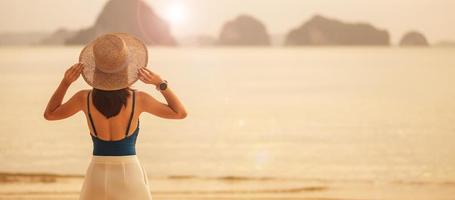 turista de mulher andando na praia paradisíaca nas ilhas ao pôr do sol. destino, desejo de viajar, viagens na ásia, verão tropical, férias e conceito de férias foto