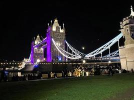 uma vista da Tower Bridge em Londres à noite iluminada em roxo foto