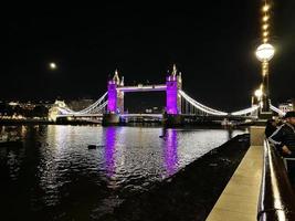 uma vista da Tower Bridge em Londres à noite iluminada em roxo foto