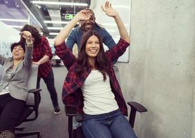 equipe de negócios multiétnica competindo em cadeiras de escritório foto