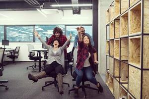 equipe de negócios multiétnica competindo em cadeiras de escritório foto