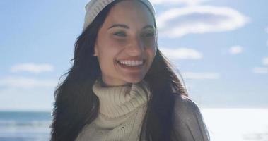 garota com roupas de outono sorrindo na praia foto