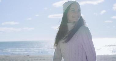 garota com roupas de outono sorrindo na praia foto