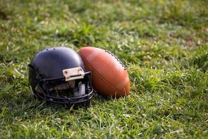 capacete e bola de futebol americano foto