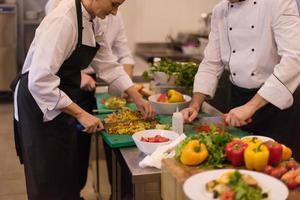 cozinheiros e chefs de equipe preparando a refeição foto