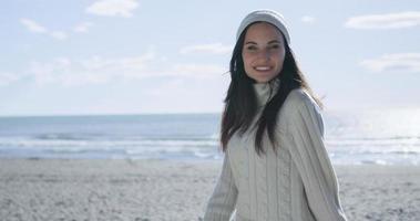 garota com roupas de outono sorrindo na praia foto